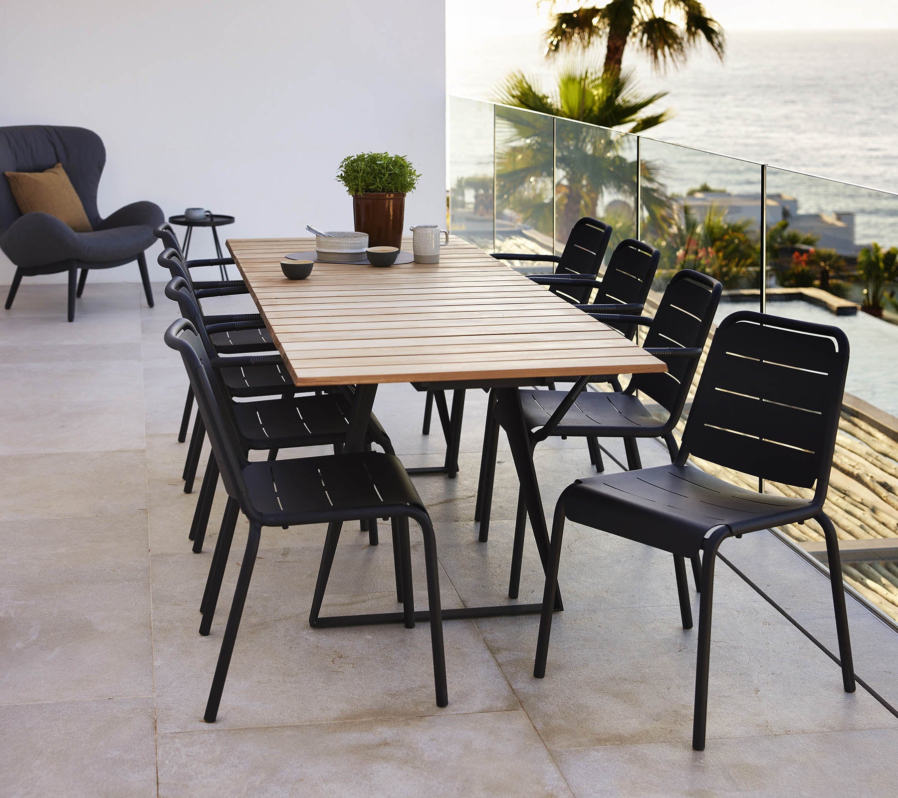 A Copenhagen table with a wooden top surrounded by black Copenhagen chairs, creating a stylish dining setup.