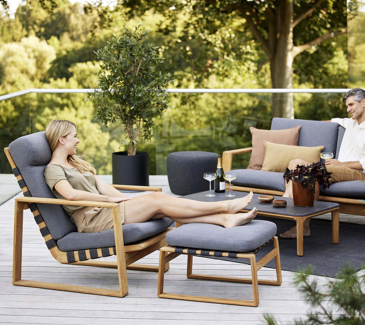 Relaxing scene featuring a highback chair and a coordinating sofa, complemented by decorative cushions and a small table.