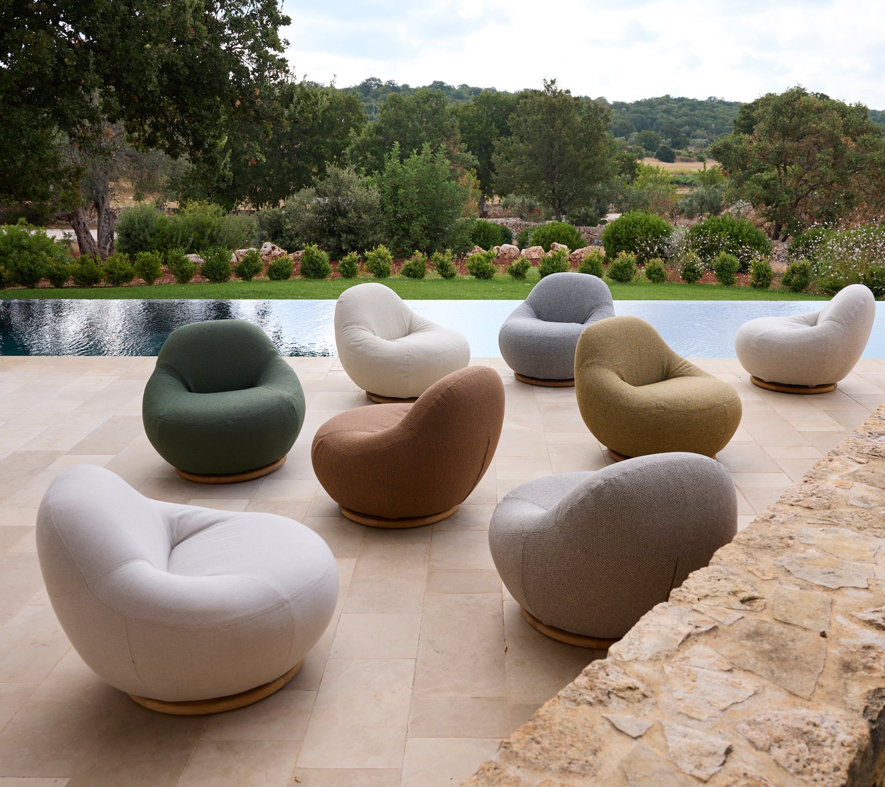 Set of modern chairs in various colors arranged around a poolside.