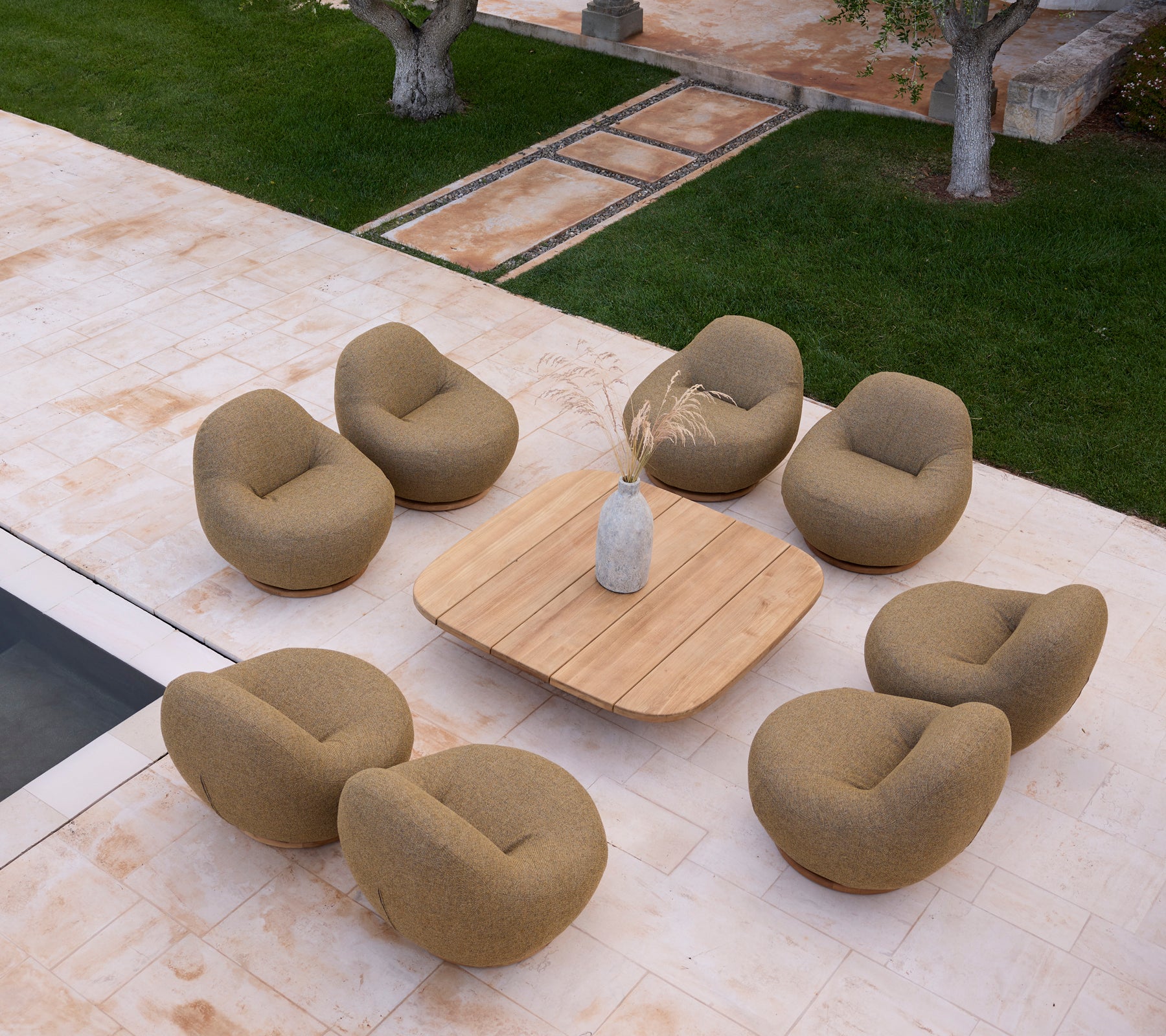 Modern lounge setup with beige chairs and a wooden table.