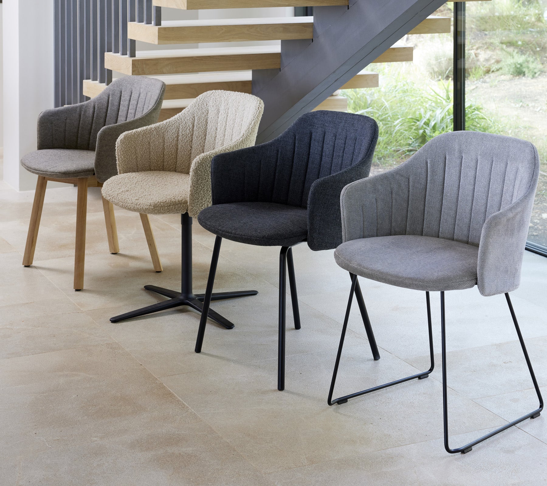 Four modern chairs in different colors and styles displayed in a contemporary setting, showcasing their unique designs.