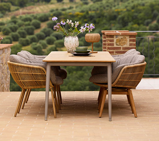 Stylish dining setup featuring a Core dining table and Stay chairs, adorned with a vase of flowers, creating an inviting atmosphere.