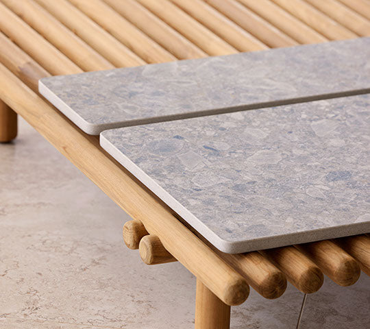 A wooden platform features two stone tabletops, highlighting a modern design with natural elements for a stylish display.