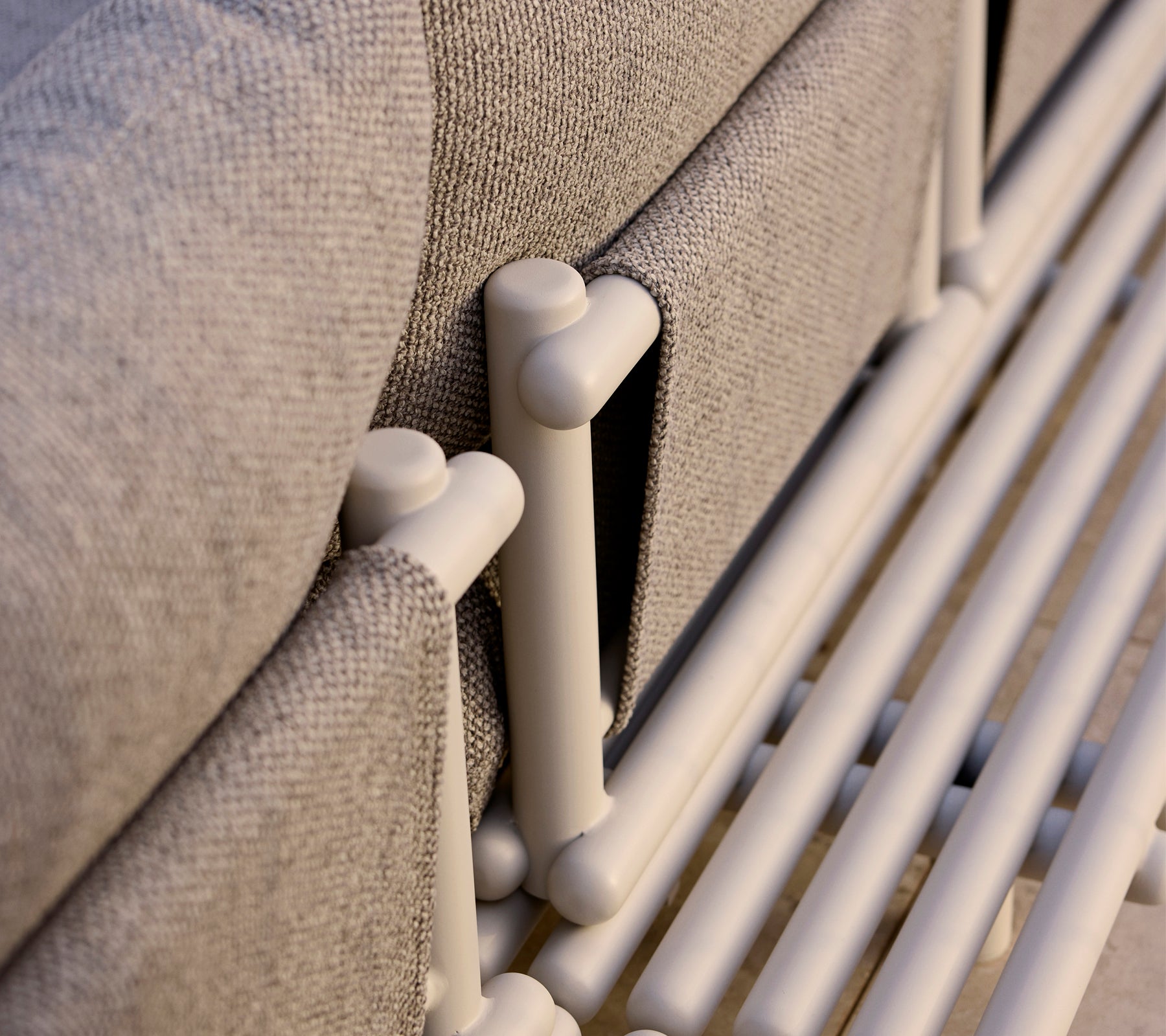 Close-up of a lounge platform featuring aluminum sticks and a textured gray fabric, highlighting modern design elements.